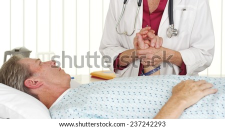 Doctor holding patient\'s hand and comforting him