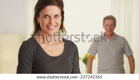 Senior couple standing in living room smiling