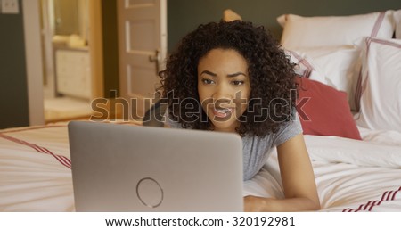 Attractive young black woman reading on a laptop computer