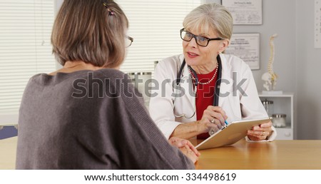 Senior woman doctor tablet talking patient