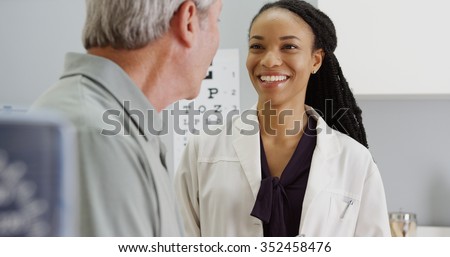 Black woman doctor talking and being positive with senior