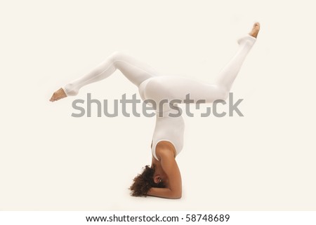 Woman in white leotard doing a head stand