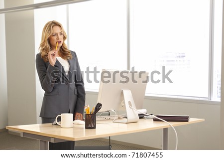 Young businesswoman standing at desk