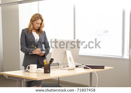 Young businesswoman standing at desk