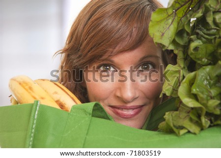 Young woman with green bag of healthy food and vegetables