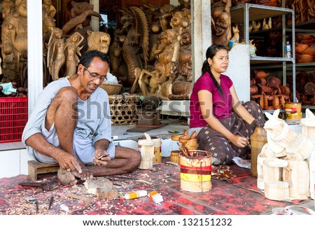 A man and a woman are making wooden crafts in Indonesia