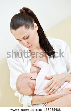 Mother nurse her child on a sofa
