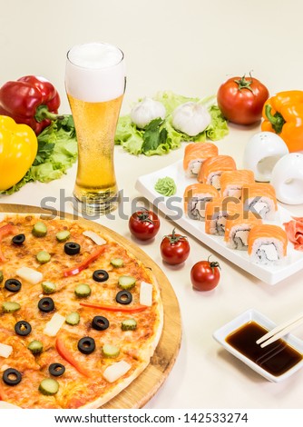 composition of beer sushi  and pizza on white background