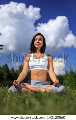 girl doing yoga outdoor with open eyes and smiling, vertical