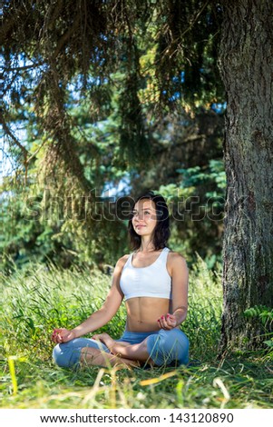 girl doing yoga outdoor with open eyes and smiling