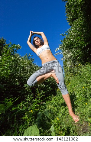 girl doing yoga outdoor and smiling, vertical