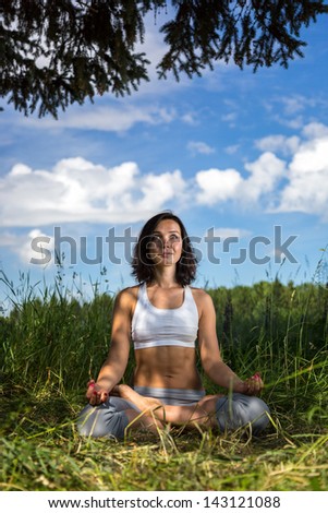 girl doing yoga outdoorr with open eyes, vertical