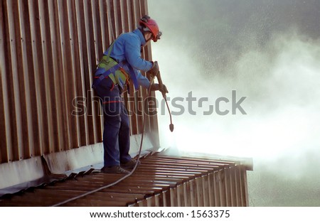 Young man, cleaning the roof of an ironworks.
