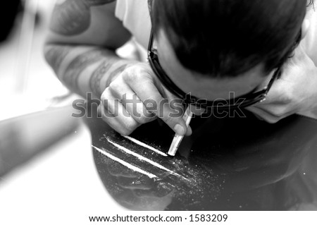 stock photo : Young man with tattoo, sniffing cocaine.