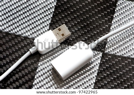 White USB cable on a carbon fibre background