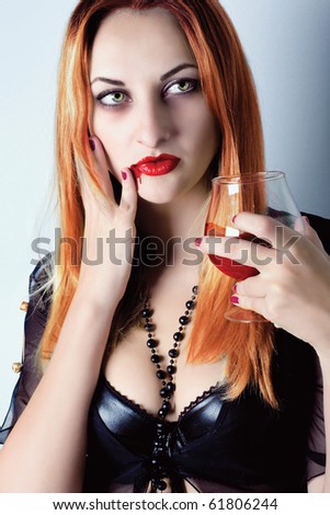 sexy vampire girl with glass of blood