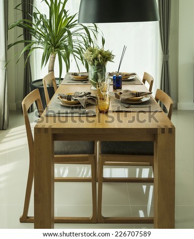 dining table and comfortable chairs in modern home with elegant table setting
