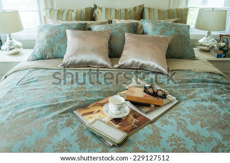 Decorative set with book,tea set and glasses on the bed