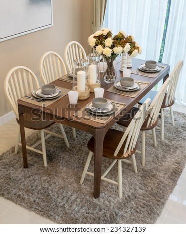 dining table and comfortable chairs in modern home with elegant table setting