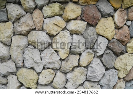 yellow, red, blue, stones and pebbles on gray wall, background, closeup