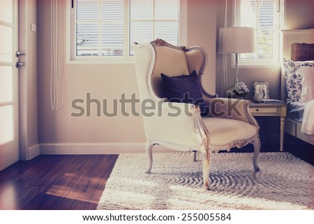 vintage photo of classic chair with brown pillow on carpet in luxury bedroom interior