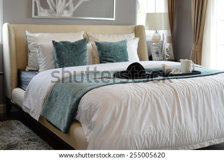 black tray of tea set with white and green pillows in classic style bedroom
