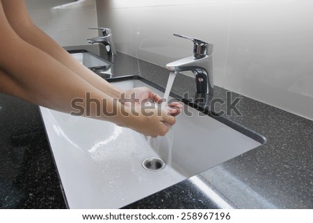 white washbasin and faucet on granite counter with hand washing