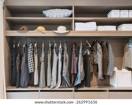 modern closet with row of dress hanging on coat hanger in wardrobe.