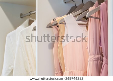 row of colorful dress hanging on coat hanger in white wardrobe