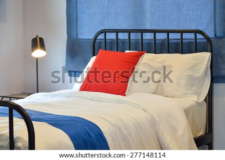 Modern bedroom interior with pillows and blue roman blind