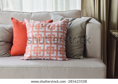 Chinese pattern  in orange and deep orange and gray pillows on light gray sofa set