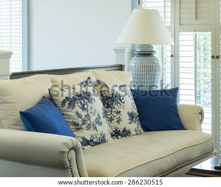 luxury living room with blue pattern pillows on sofa and decorative table lamp