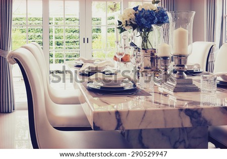 grain and vintage effect photo of dining table and comfortable chairs with elegant table setting