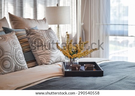 luxury bedroom interior design with decorative tea set and striped pillows on bed