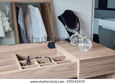 Crystal jars and necklace on wooden dressing table