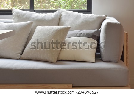 Beige varies size pillows setting on light gray comfy sofa