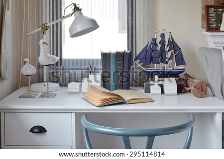 white table with wooden chair books and lamp in modern working area at home