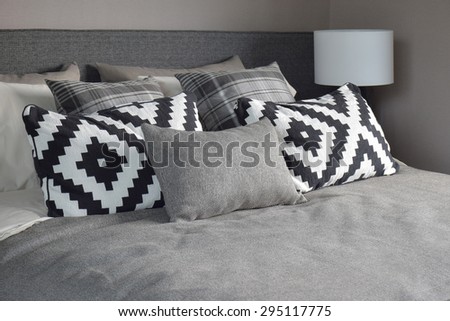 Graphic style and grey shade pillows on classic color bedding set up