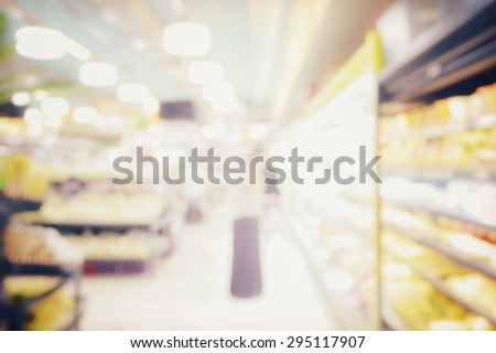 blurred abstract background of people shopping in supermarket with miscellaneous product on shelves
