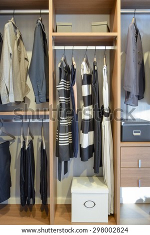 row of black dress,shirts and pants hang in wardrobe