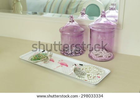 Beauty and make-up concept: mirror,jewelry and makeup set on a dressing table