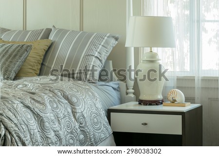 cozy bedroom interior with pillows and reading lamp on bedside table