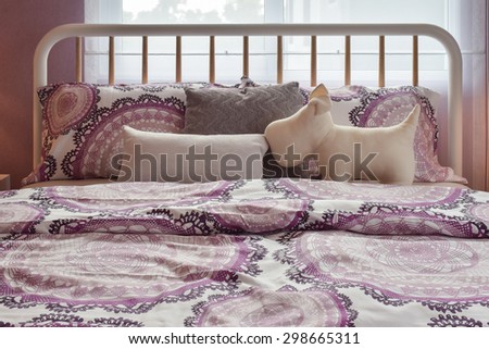 Cozy bedroom interior with purple pattern pillows on bed