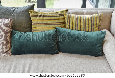 Retro pillows on the cozy brown sofa in modern living room