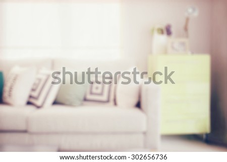 blur image of cozy sofa with geometric pattern pillows and sideboard in living corner with vintage effect