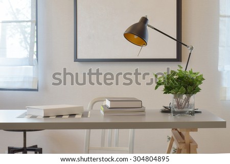 work table with book lamp, and vase at home