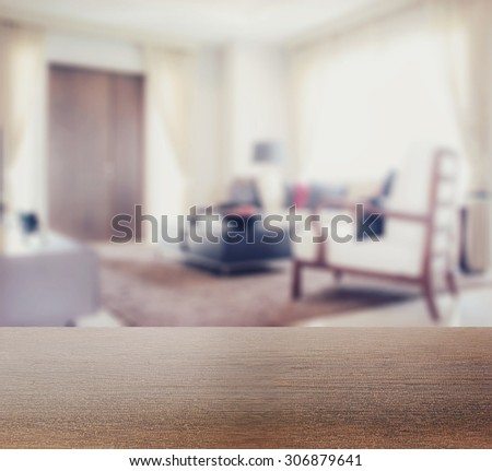wooden table top with blur of modern living room interior as background