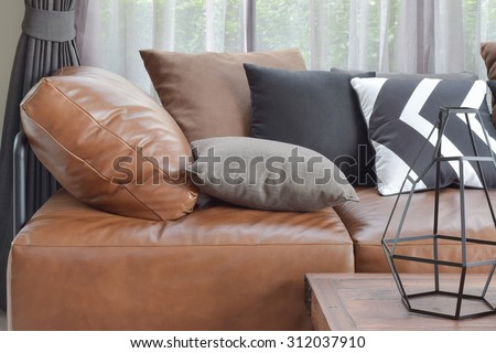 Light brown leather sofa bed with varies color and size pillows
