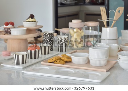 Cookies and cupcakes with cute bake ware setting on white top table