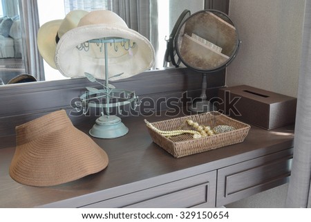 white hat and jewelry set on a dresser table in a contemporary room.